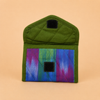 A small quilted fabric pouch or card holder in olive green with a colorful striped panel in blue, green, and purple, featuring two black hook-and-loop closures, shown on a solid peach background.